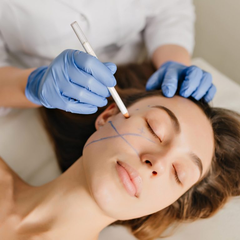 Closeup portrait of beautiful woman during the preparation to cosmetology therapy in beauty salon. Professional dermatology procedures, lifting, rejuvenation